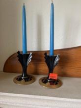 Two blue candles, and black and gold candleholders