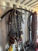 LOT OF ASSORTED STEEL LIFTING CABLES & SNOW CHAINS CABLES & CHAINS HANGING ON WALL INSIDE OF STORAGE