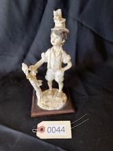 Figurine with young boy and squirrel on hat