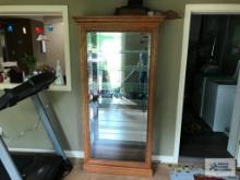 OAK LIGHTED CURIO CABINET WITH GLASS SHELVES AND SIDE DOORS.