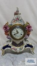 Antique Dresden ceramic and metal clock with key. 14-1/2 in. tall.
