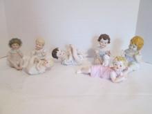 Seven Vintage Bisque Piano Baby Figurines