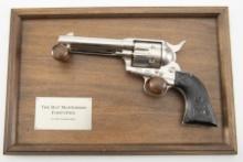 A wall mounted non-firing Revolver on wooden hanging mount, titled "The Bat Masterson .45 caliber,