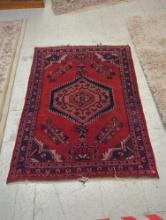 HAND MADE ANTIQUE AREA RUG. FLORAL ACCENTS, RED, AND DARK BLUE. 44 1/2"X60"