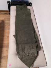(BR2) MILITARY GREEN CANVAS CARRY BAG WITH BACK STRAPS. IT MEASURES 41" LONG.