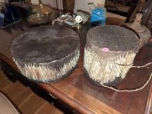 (UPOFC) LOT OF (2) AFRICAN HANDMADE DOUBLE SIDED COWHIDE DRUMS. THE LARGEST ONE MEASURES 11" DIA X