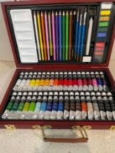 Art set. Colored pencils and watercolor paints and brushes in wooden case
